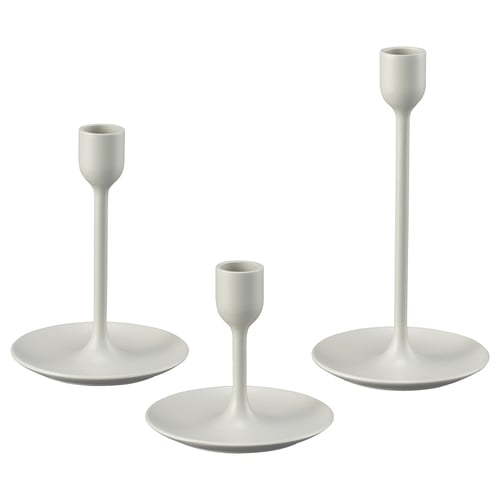 Three white candlesticks of varying heights, sleek and modern design, made of aluminium with felt pads.