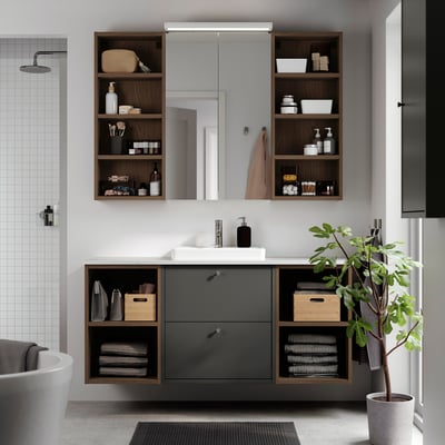 Modern grey bathroom setup with HAVBÄCK cabinets and counter, featuring open & closed storage, plus sleek sink.
