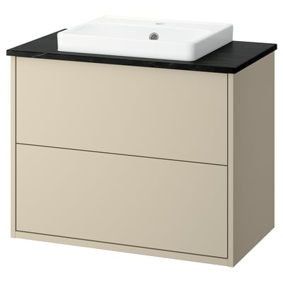 Displays a beige HAVBÄCK bathroom vanity. It sleek drawers and a black countertop with a minimalist white basin.