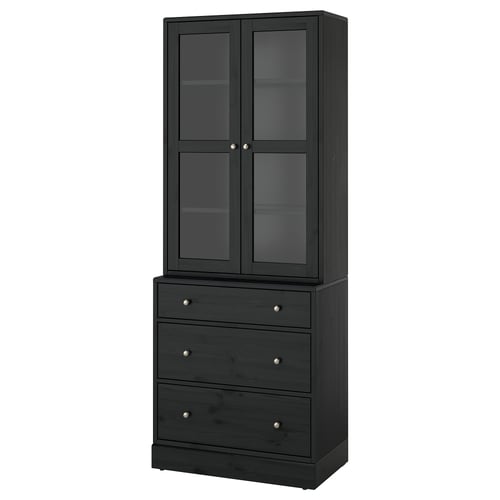 HAVSTA: tall black wooden cabinet with glass doors and three drawers, displaying rustic design.