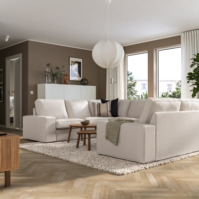 Modern living room with KIVIK sofa. Low armrests, large windows, decor.