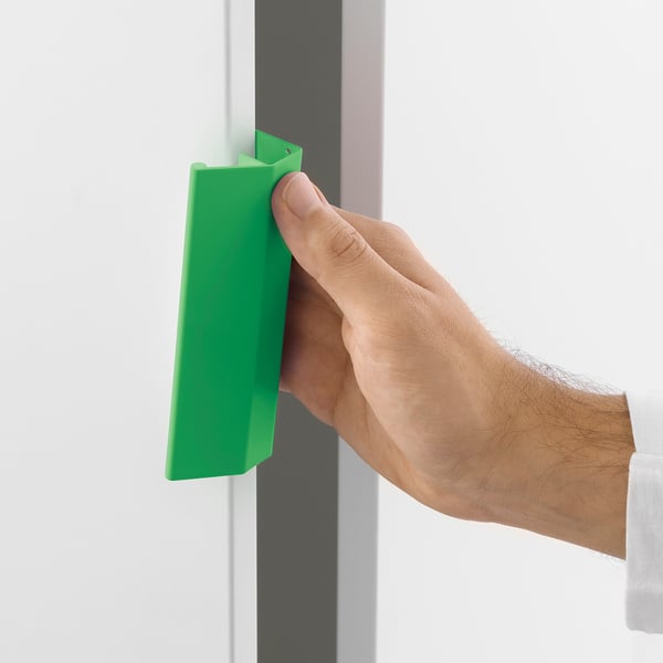 Hand holding green LÄTTHET handle, clamps on platsa drawer without drilling.
