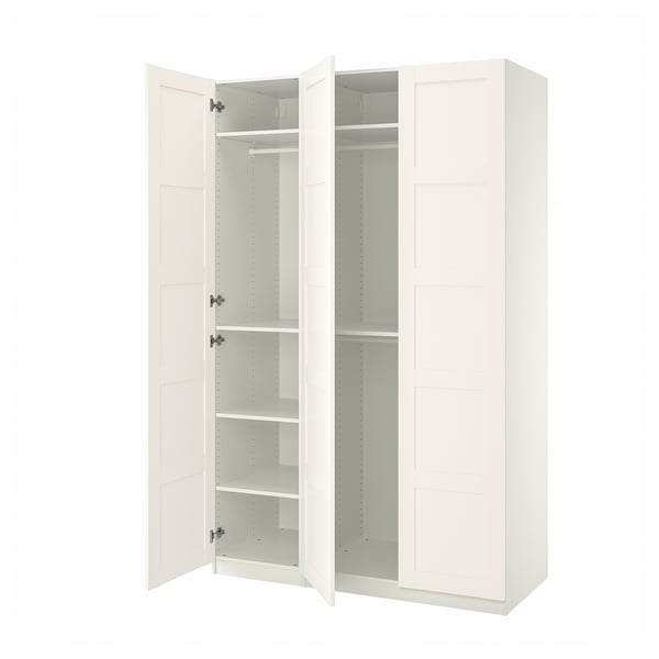 A white IKEA PAX wardrobe with open doors revealing shelves and a clothes rod.