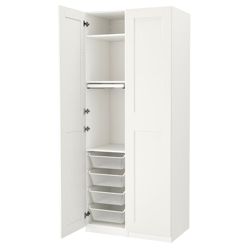 A white ikea PAX wardrobe with open doors, revealing shelves and mesh drawers.