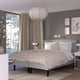 Modern bedroom with grey RÅHOLMAR bed, 5 comfort zones, geometric bedspread, pendant light, and window with beige curtains.
