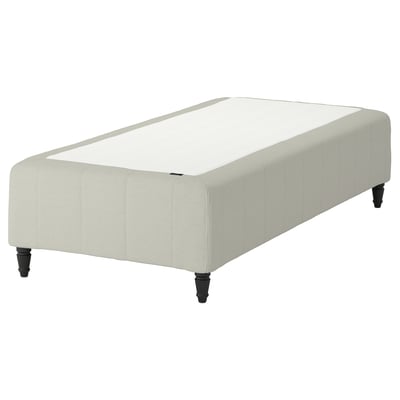 The RÅHOLMAR bed base, featuring a light beige upholstery with wooden legs. The bed is rectangular and has a padded, quilted design for comfort.