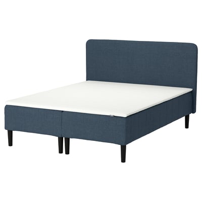 A blue RENFJÄLLET bed with a soft headboard and a white mattress pad. It a wooden frame and dark legs, designed for comfort and easy assembly.