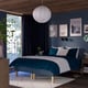 Modern blue bedroom with teal bed, white pendant, dark curtains, and wall art. Large bed dominates room.