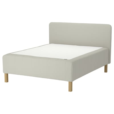 A white RISHÖJDEN upholstered bed with a padded headboard and wooden legs.