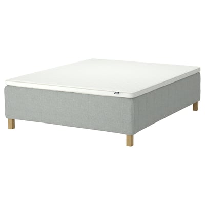 Rishojden mattress in light blue fabric with white top, rectangular, raised on wooden legs.