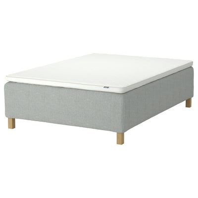 Image shows a light grey RISHÖJDEN mattress set on a wooden bed frame. A white mattress topper. The bed has square wooden legs.