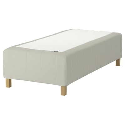 A RISHÖJDEN white mattress base, with wooden legs, rectangular shape, and a padded design for comfort. It has a sturdy build and a minimalist style.