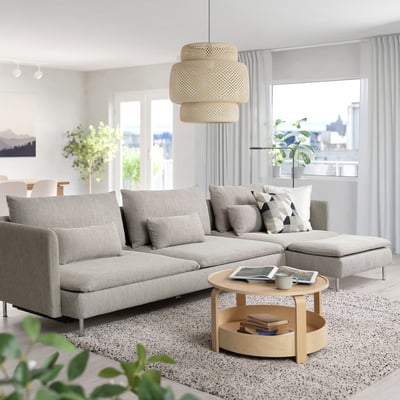 Modern living room with light grey SÖDERHAMN sofa bed, wood coffee table, large window, hanging lamp, and plants.