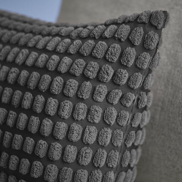 Textured, dark grey cushion cover with intricate, repeating, raised patterns, showcasing high-quality craftsmanship and detailed design.