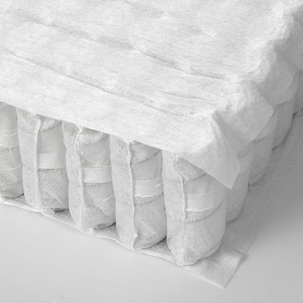 Close-up of a rolled mattress showing visible comfort zones, indicating quality support.