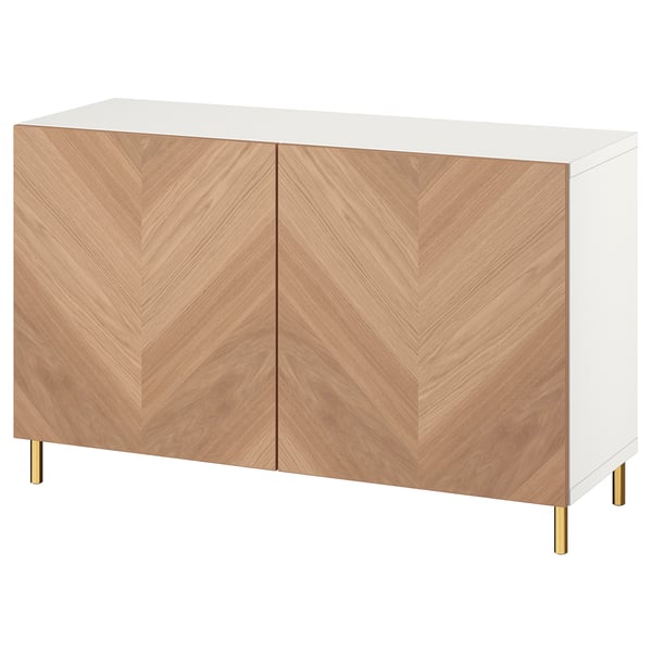 An ikea BESTÅ sideboard in white with two herringbone-patterned oak doors and gold legs.