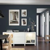 Modern living room with BESTÅ sideboard, dining area, and dark blue accent wall.