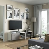 Modern living room with BESTÅ tv bench. Adjustable shelves and cable management keep it clean and organised. Flat-screen tv with decorations.