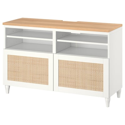 Modern white tv console with wicker doors and wooden top.
