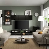 Modern living room with BESTÅ dark grey tv unit, light grey sofas, black coffee table, and wooden flooring, all neatly arranged.