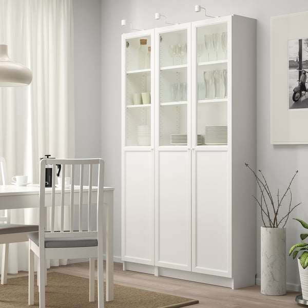 White BILLY bookcase with glass doors in dining area.