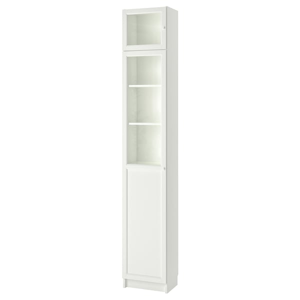 A white BILLY bookshelf with glass and panel doors, standing tall and slim.