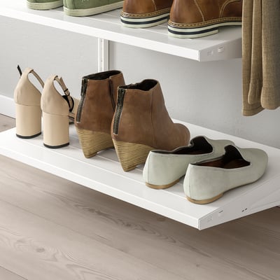 White shoe shelves mount on wall, holding various shoes. Organises footwear neatly, preventing clutter.
