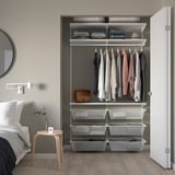 Modern closet with white BOAXEL storage. Hanging clothes, folded items, and mesh drawers. Fits neatly beside a bed, with a minimalist design.