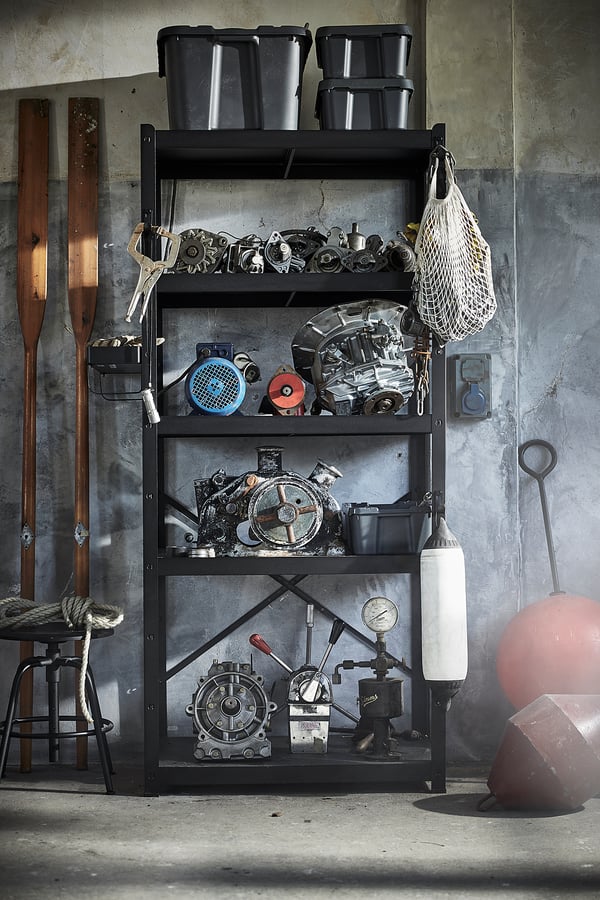 Black metal storage shelves hold various tools and equipment, ideal for garages or workshops.