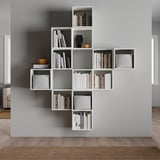 Elegant white wall-mounted bookshelf named EKET, featuring varying cubed compartments for storing books and decorative items.