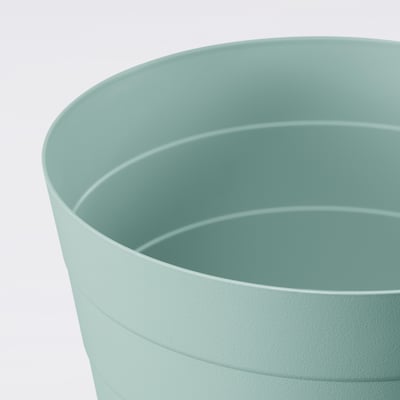 A FNISS waste bin in turquoise. Its made of durable recycled polypropylene. The bins cylindrical shape clean horizontal lines.