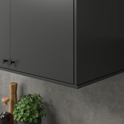 Grey cabinet, black handle, light, plant, coffee.