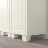 White kitchen cabinet legs, adjustable for uneven floors. Simple, sturdy support.