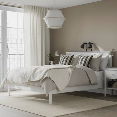 Modern bedroom white GULLABERG bed with a traditional design. The bed is large, surrounded by nightstands. Soft lighting enhances the serene ambiance.