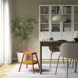 Orange step stool near desk, sturdy & compact for seating or reaching.