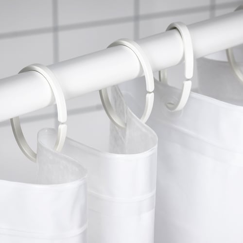White shower curtain rod with hooks holding an opaque, waterproof curtain for privacy.