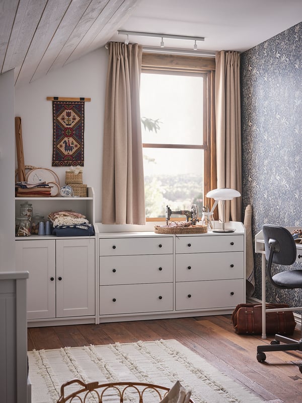 Cosy room with HAUGA white dresser, beige rug, wooden floor, and large window with curtains.