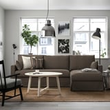 Modern living room with large brown HYLTARP sofa, white coffee table, black pendant lamp, and plant.