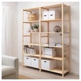 IVAR storage shelves, light wood, 5-shelf unit. Tall, holds white boxes, books, basket & lamp. Beige curtains & couch beside.