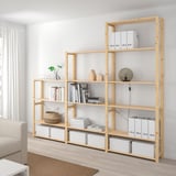 IVAR light wood shelves hold books & boxes, taller than couch, minimalist.