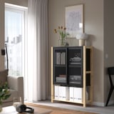 Modern living room with IVAR storage, metal mesh doors, flowers.