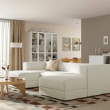 Modern white JÄTTEBO sofa in cosy living room with deep seats, chaise lounges, bouclé cushions, wooden furniture, rug, wall art, and curtains.