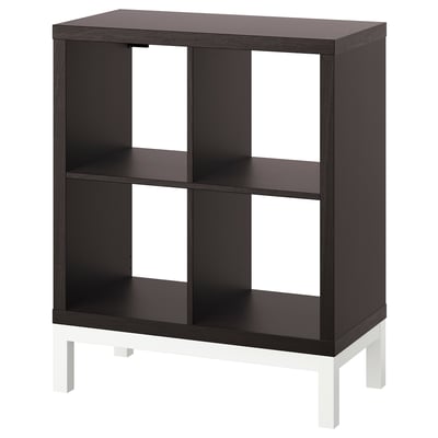 Depicts an ikea KALLAX black and white shelving unit. It has a rectangular, modular design with four compartments and four legs.