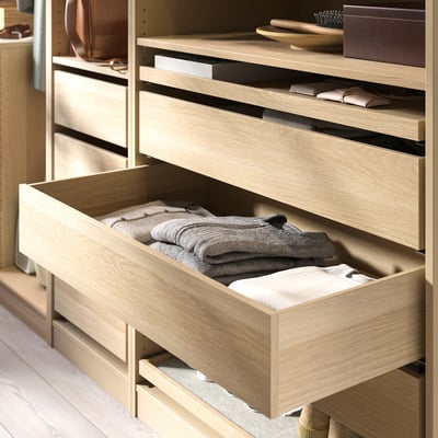 KOMPLEMENT wooden drawer holds folded clothes, neat and light-colored.