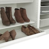 Closet shelf with pull-out section holding various shoes. Includes different styles like boots and heels.