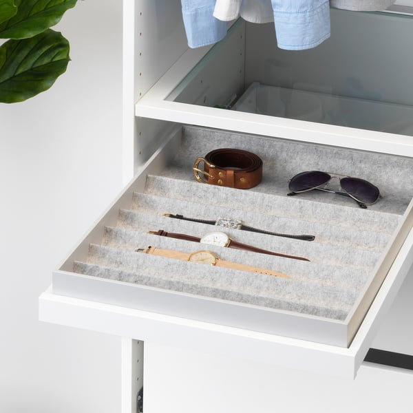 White wardrobe drawer with grey felt interior holds watches, sunglasses, and a belt, featuring organised compartments and smooth pull-out mechanism.