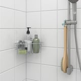 Shower caddy with suction cups holds shampoo, soap near showerhead.