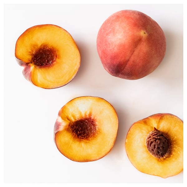 Four peach halves and one whole on white. Vibrant orange flesh, dark pits. Simple, clean layout.