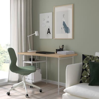 Modern home office with LAGKAPTEN desk, green chair, laptop, & art.