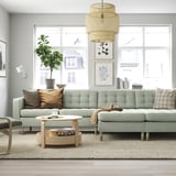 Modern living room with green LANDSKRONA sofa, wooden coffee table, and large window.